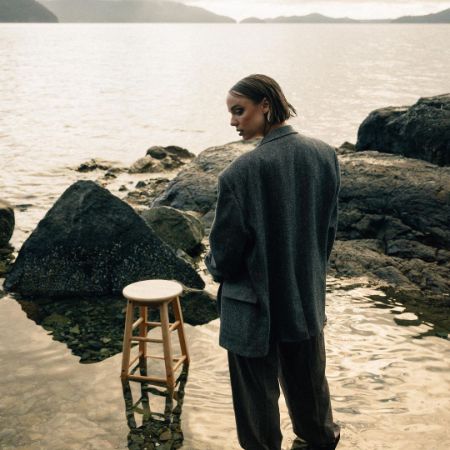 Emily Haine is posing on a suit at the lake.